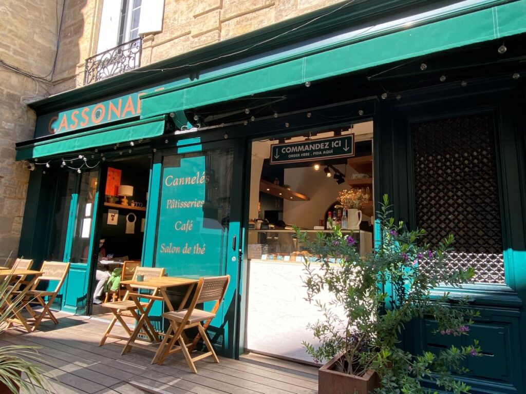 Bordeaux Cancale cafe from outside with bright turquoise facade and tables and chairs outside