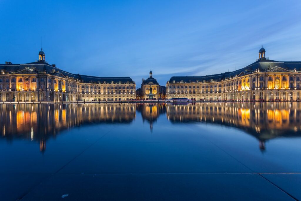 Le Miroir d'Eau in Bordeaux with classical buildings in background and water in front with reflections