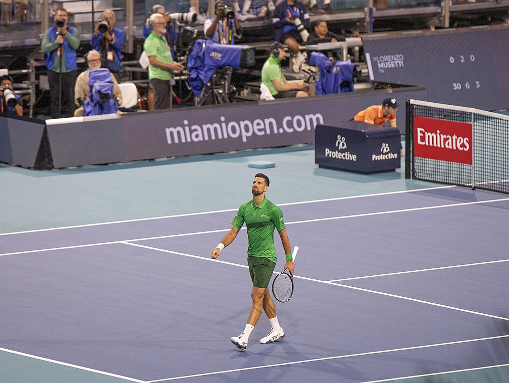 Novak Djokovic at Maimi Open 2025 in green walking away from net
