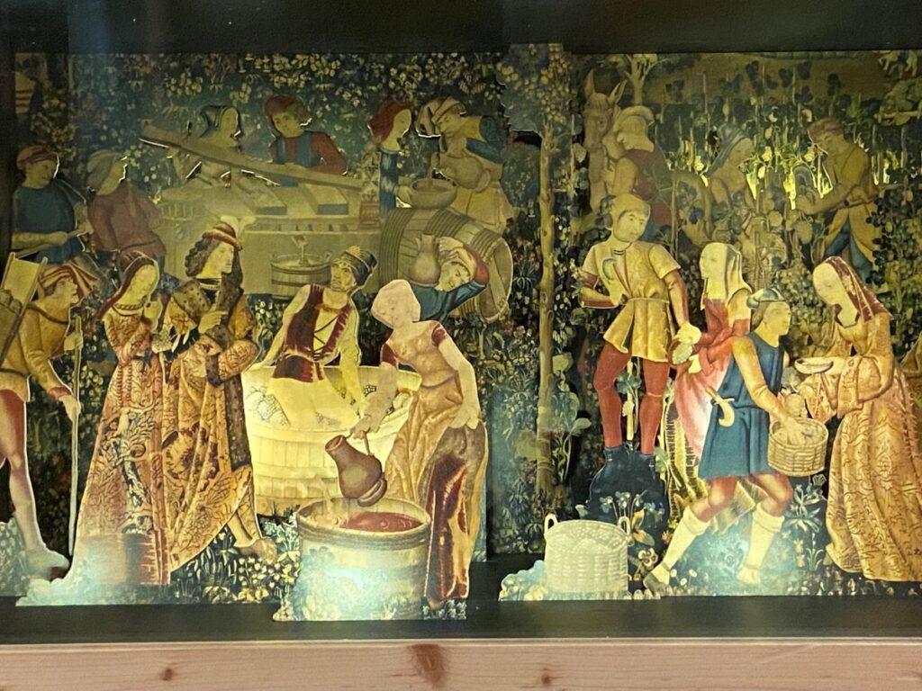 La cite du vin tapestry showing people making wine anddrinking it