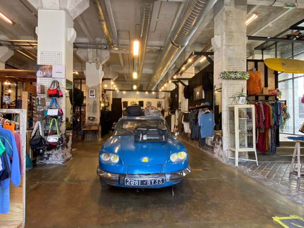 Bordeaux shops in darwin with blue car i middle of long industrial space with small shops each side