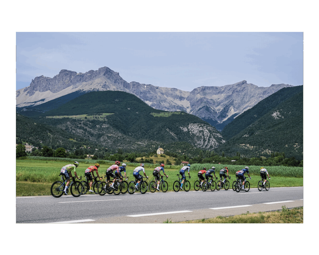 Tour de France 2024 cyclists going away from camera on road with mountains behind