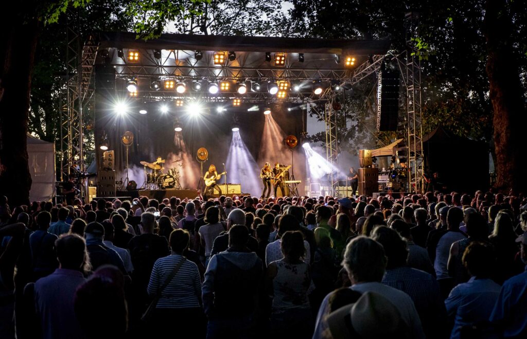 Cognac blues festival with band on stage and photo taken from back of audience