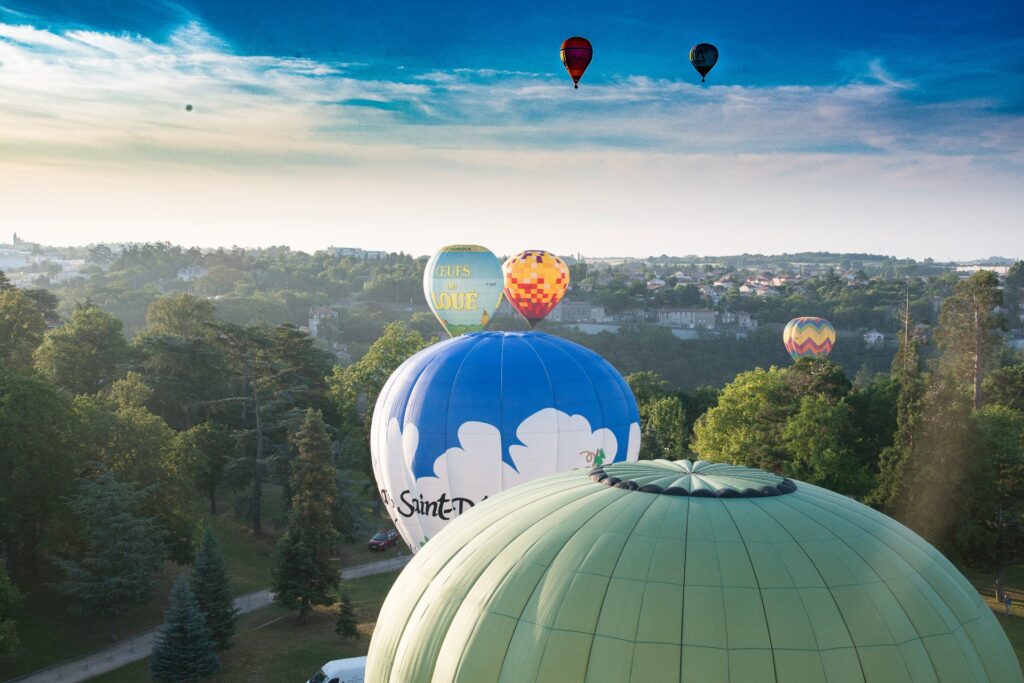 Annonay hot air ballons pictured in sky, multicoloured over countryside