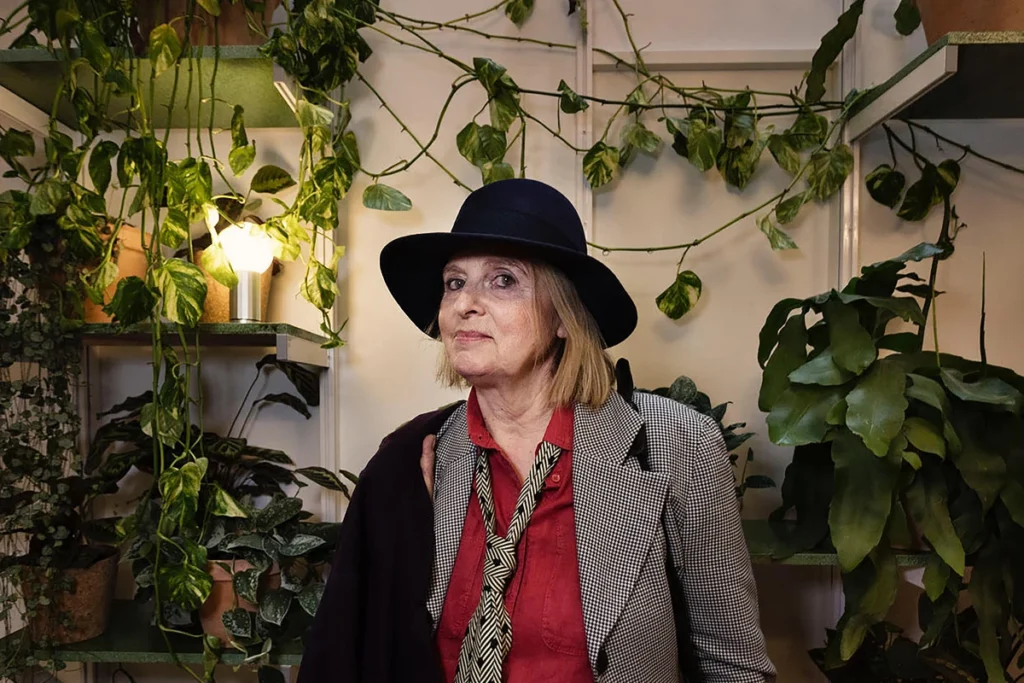 Paris Book Fair 2025 with Elizabeth Bremi kids author in blackhat against wall full of objexts