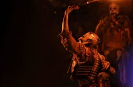 Sedan medieval fair with man at night in strange costume with fire in air