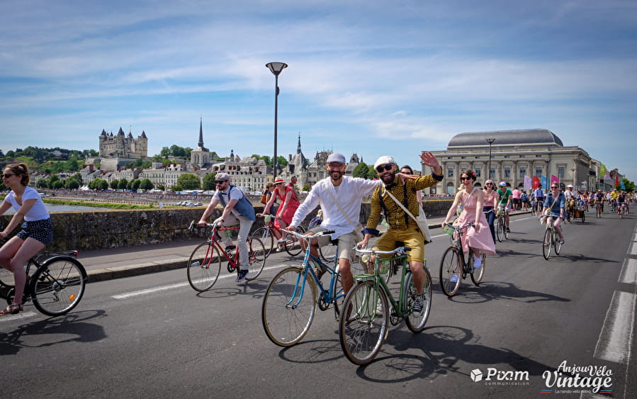 Anjou vintage velo festival with riders on old bikes crossing bridge