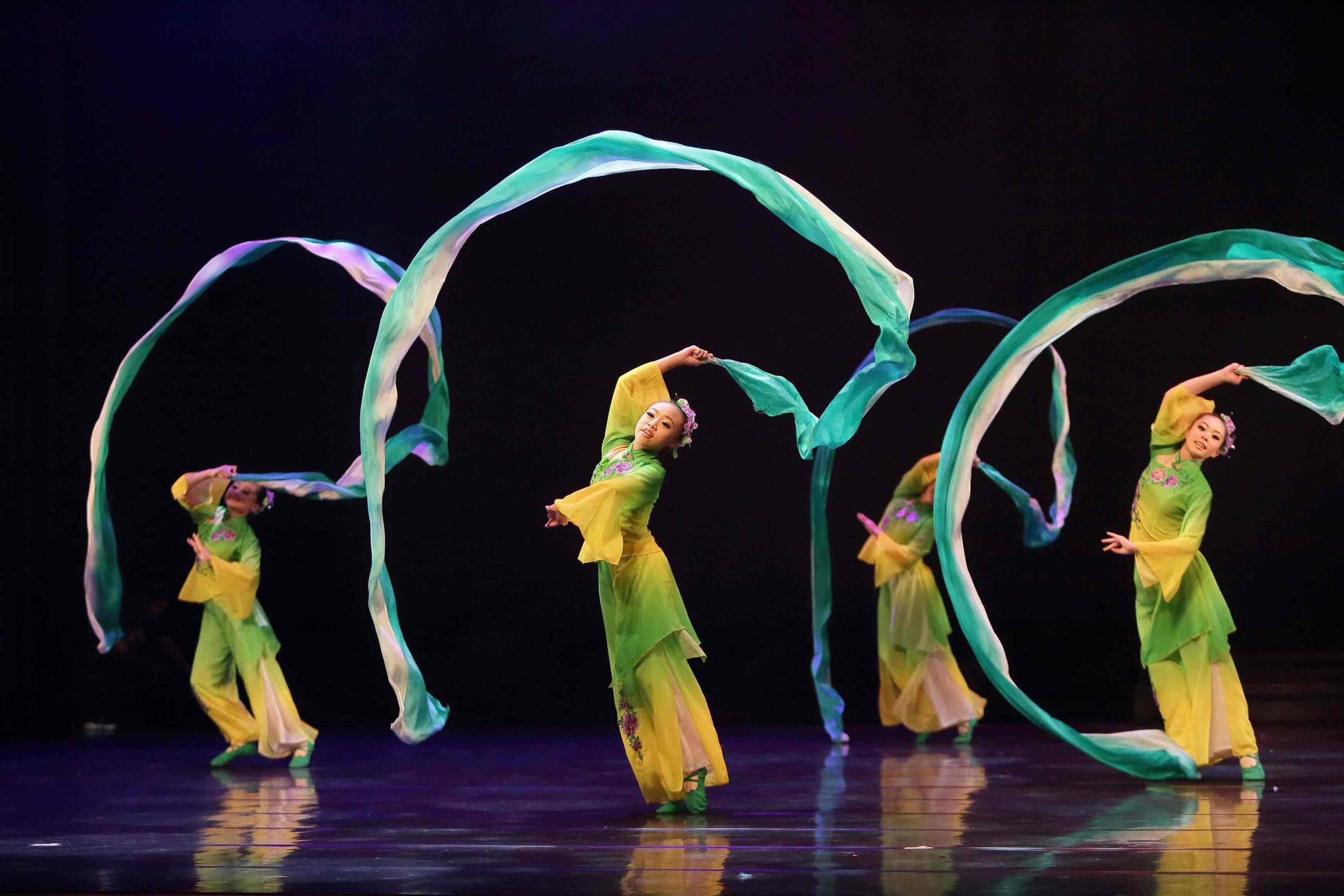 Montoire Festival with girls dancing in green and yellow with big green furls above them