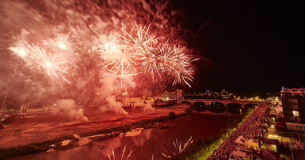 Dax Feria fireworks across river with spectators on other side