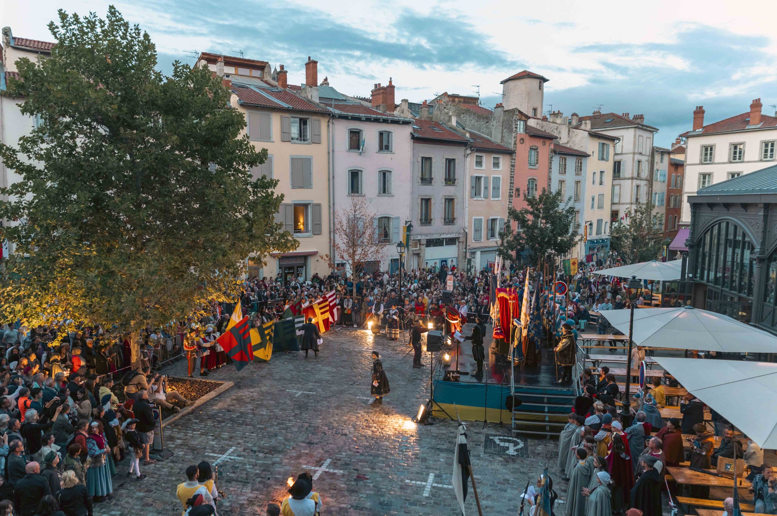 Main squareof Le Puy at dusk with stalls, and performers in streets