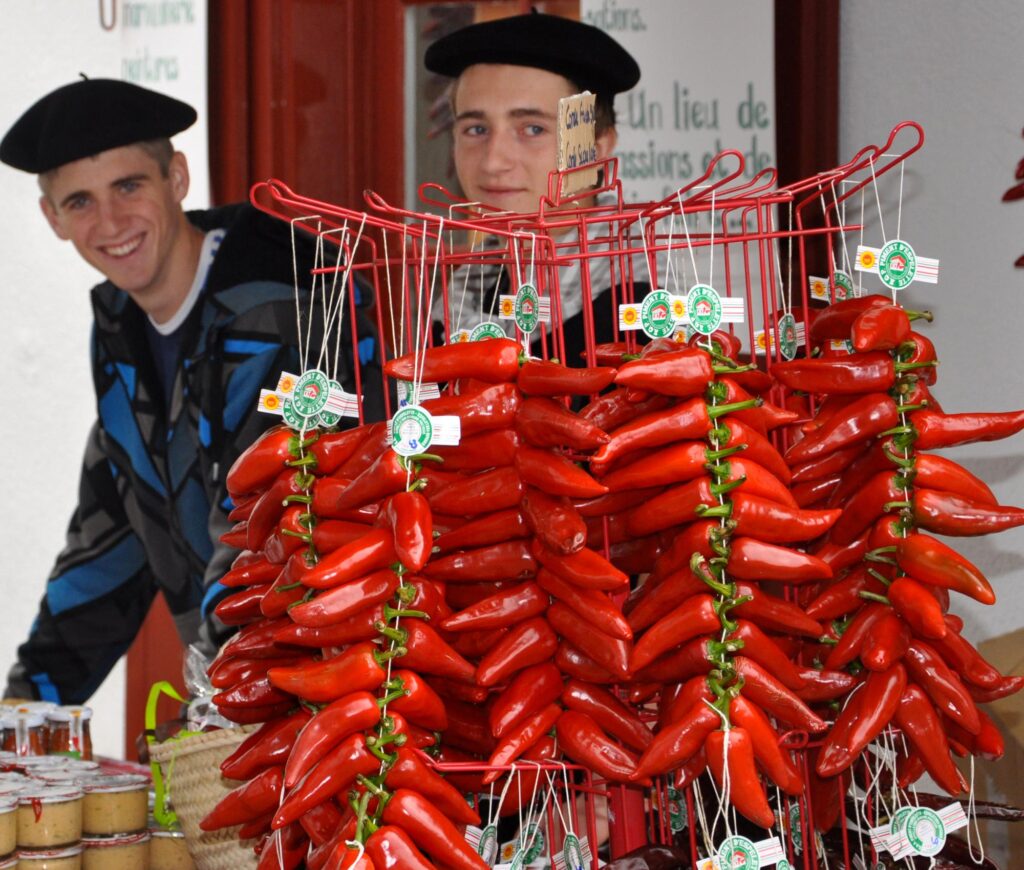 Piment festival in Espelette with two young men behind large rack of hanging pimentos