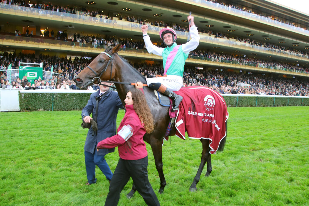 Qatar prix paris with jocky on horse with hands in air