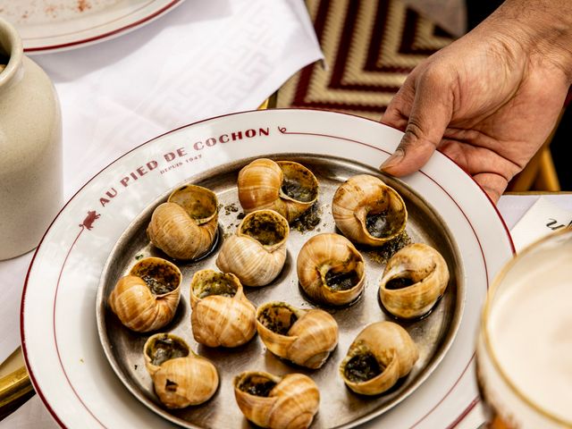 Cooked snails on a plate with Au Pied de Cochon on plate