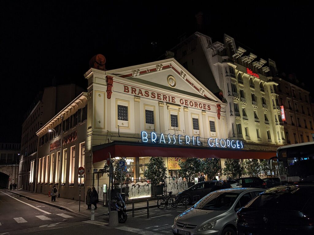 Brasserie Georges Lyon outside showing building looking like a theatre with arch, and 2 toreys and awning over terrace with name