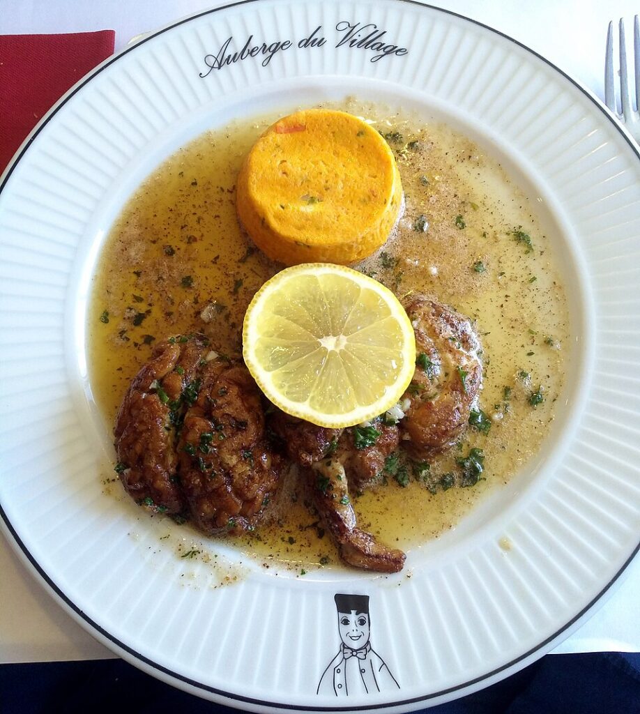 sheeps brains dish with brains onplate covered in buttery sauce and lemon wedge
