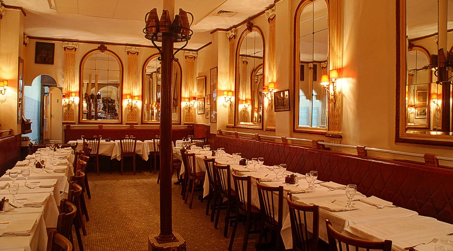 Chez Georges Paris restaurant interior with mirrors on walls, linen tablecloths and air of wealth