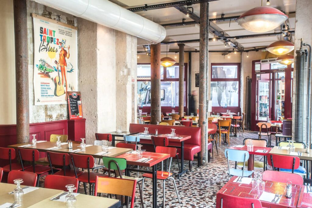 Chez Gladines Les halles with in industrial style space, funky art on walls, red topped tables and bright plastic chairs