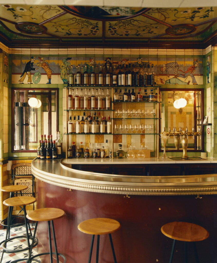 Le clown Bar Paris showing curved very smart bar with stools and bottles on wall behind