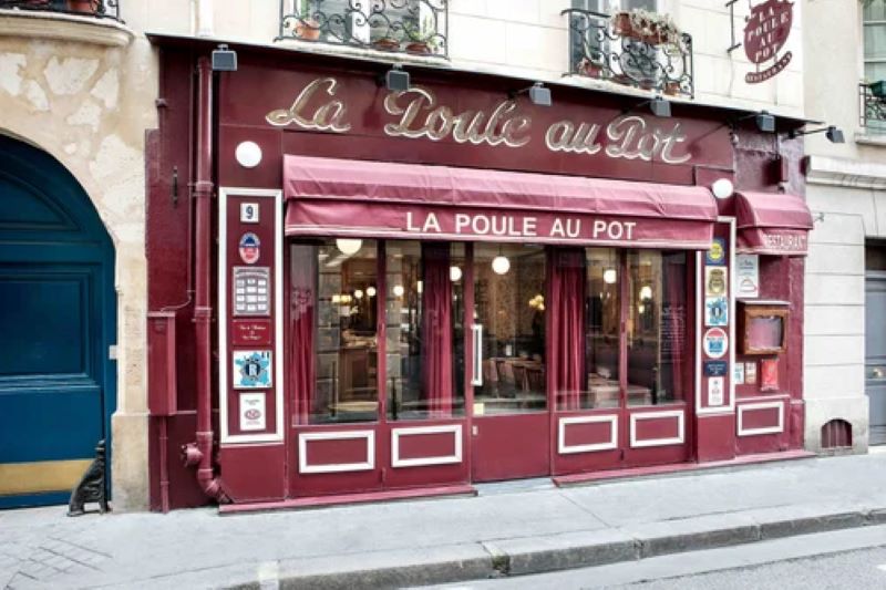 La Poule au Pot restaurant Paris showing dark red facade with name in gold and large windows