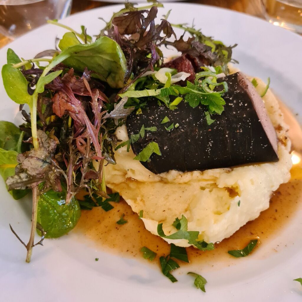 Andouille at Puteaux restaurant showing andouille on top of mashed potato