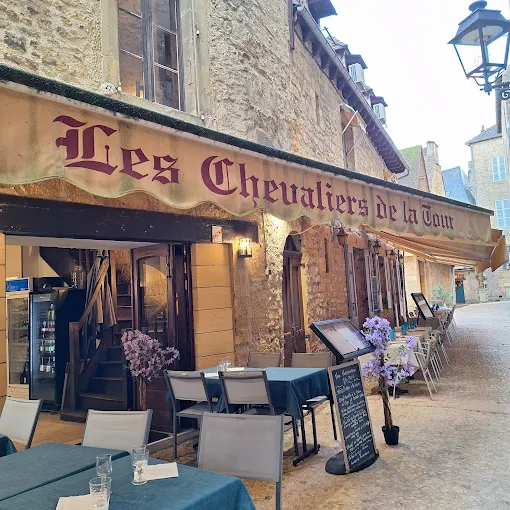 Les chevaliers de la Tour restaurant in Sarlat. Outside in private passageway with in old stone house with name on awning over outside tables