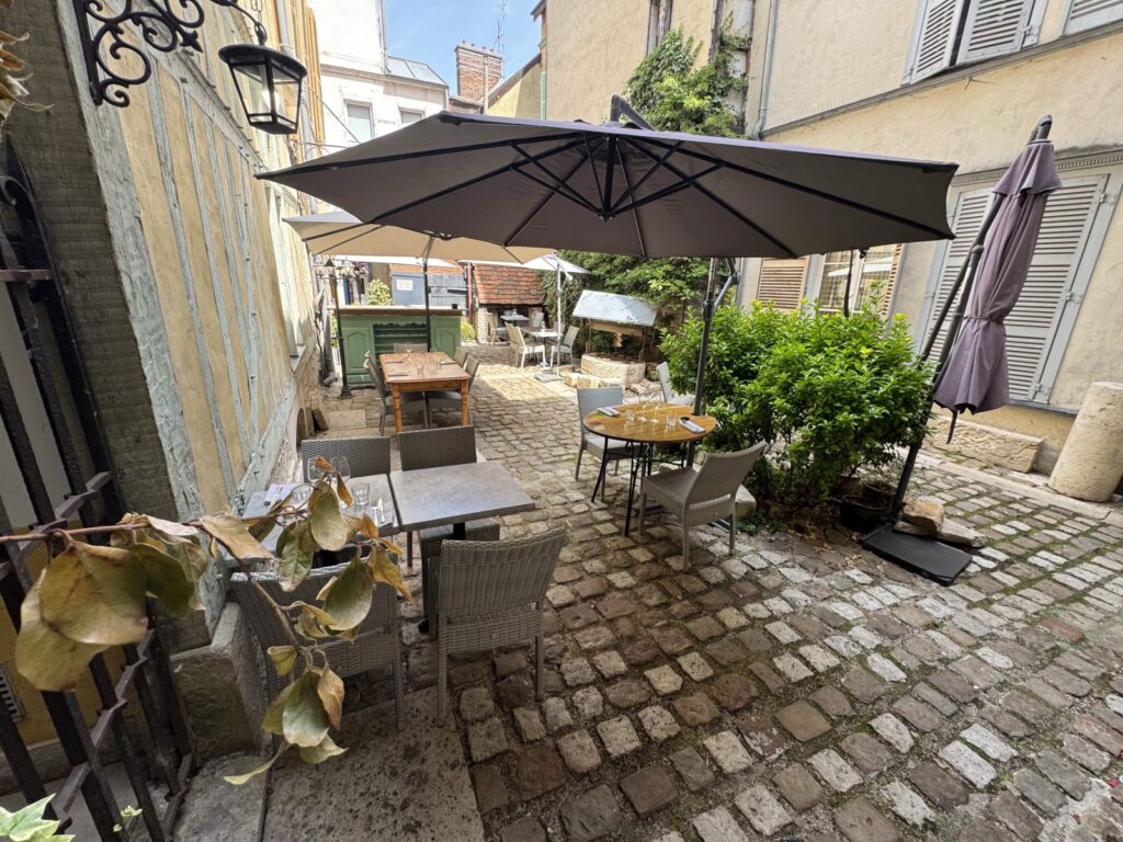 Octave restaurant Troyes showing passageway with tables and large umbrella over them
