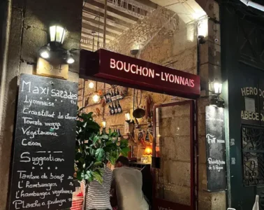 le Bouchon les Lyonnais from outside with big entrance door and blackboard outside with menu