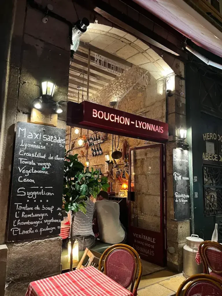 le Bouchon les Lyonnais from outside with big entrance door and blackboard outside with menu