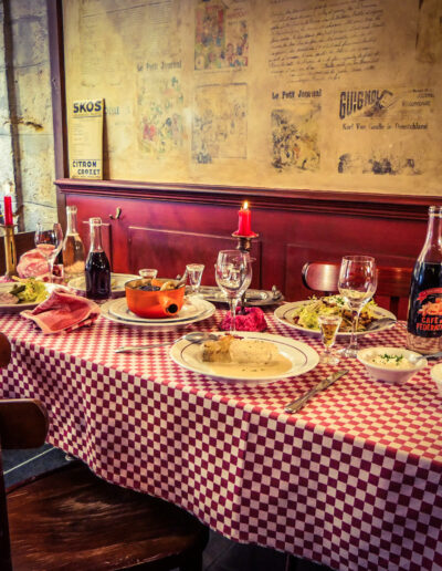Cafe des Federations in Lyon interior with red banquette table with gingham red and white tablecloth and glasses and plates on table