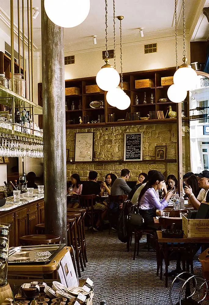 Le Comptoire de la Gastronomie Restaurant Paris with interior with tables and people eating, posters on walls
