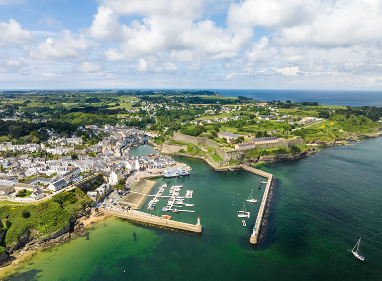 Aerial view of Belle-Ile harbour with boats at anchor, sea wall, town and hills behind