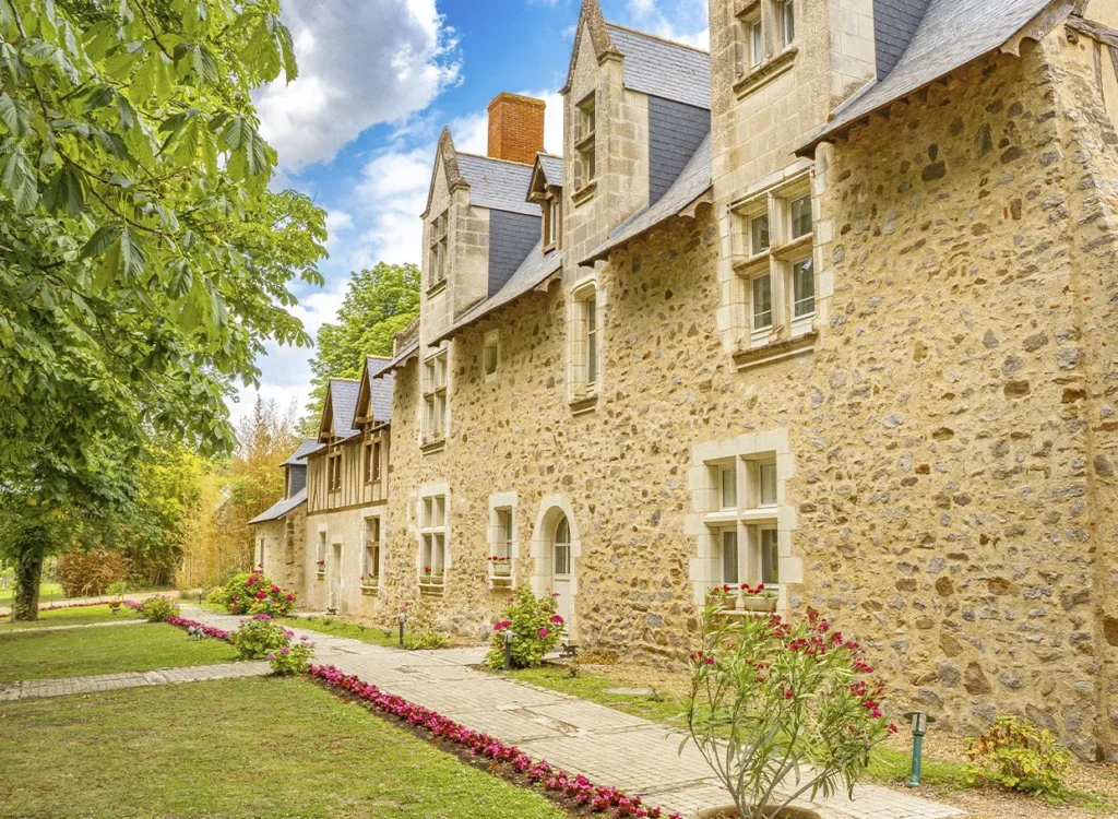Manor at chateau de noirliaix in Loire Valley. Warm stone manor house 3 storeys high with flower beds in front
