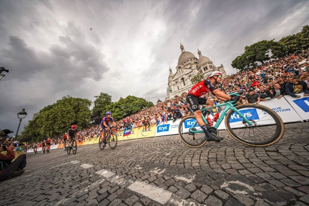 Tour de France 2025 final dayin Paris with cyclists on street and Sacre Coeur in background Montmartre
