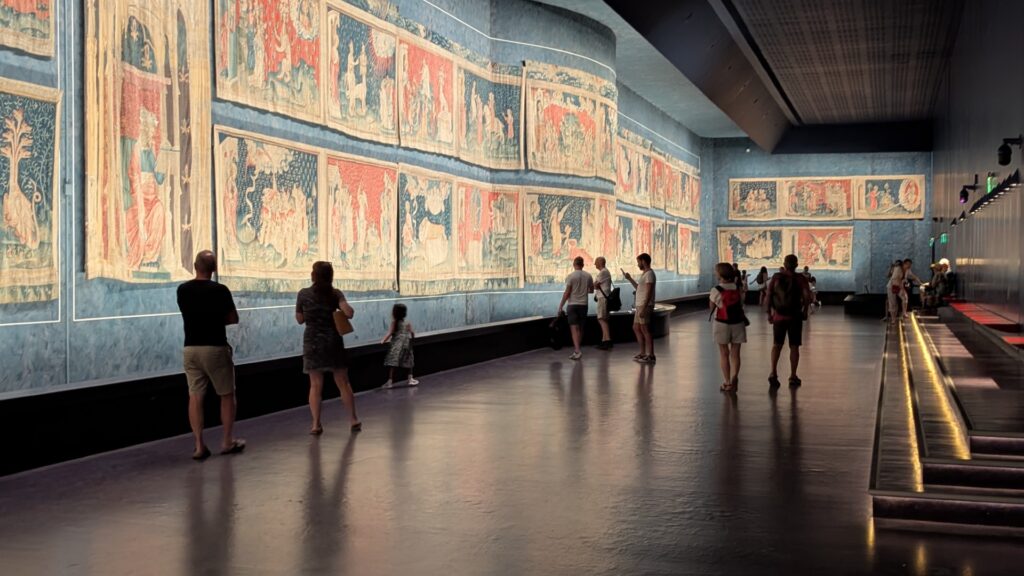 apocalypse Tapestry Gallery, Angers with people walking along beside huge tapestry panels