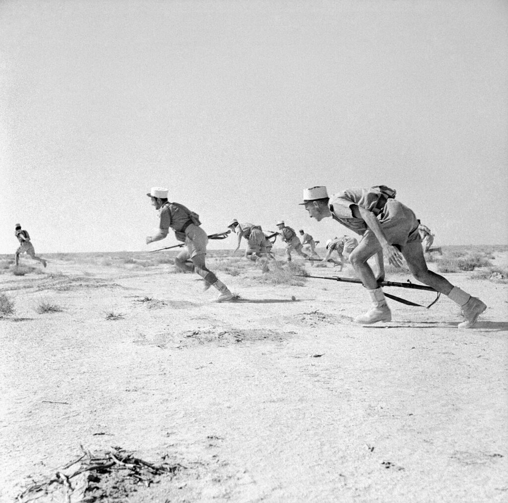 Black and white photo of Free French foreign legioneers breaking out into desert at Bir Hakeim