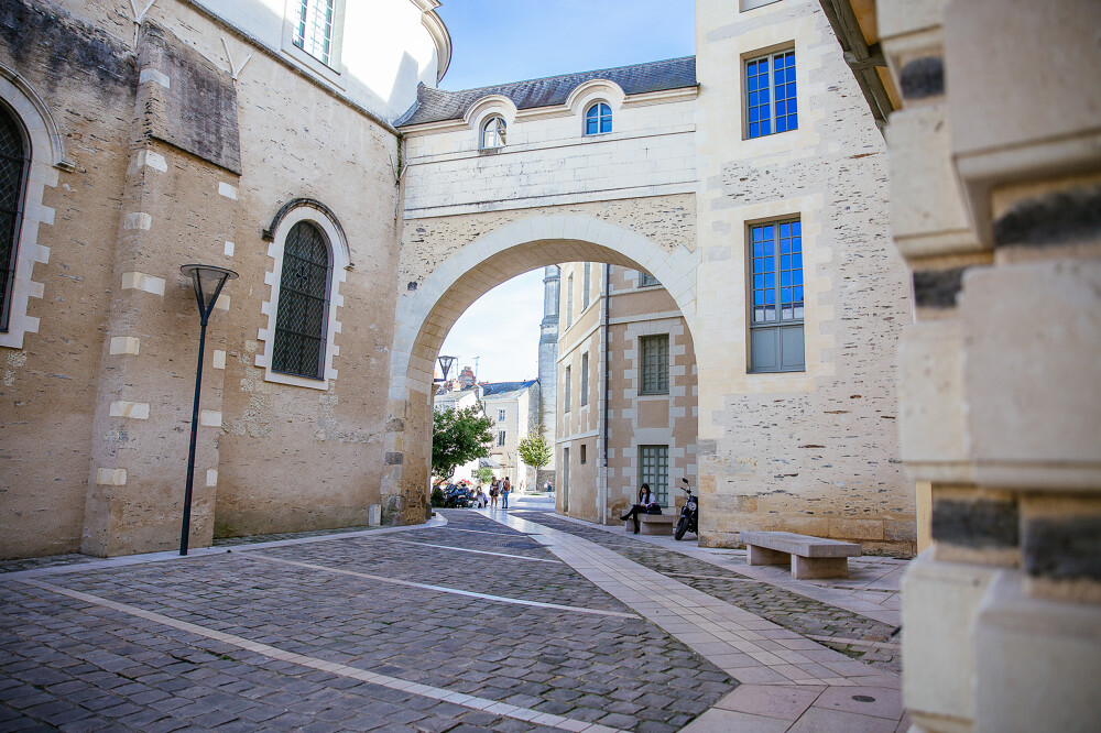 Museum street Angers with old walls and bridge over street