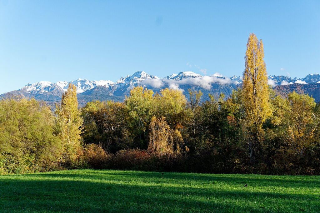 Looking towards Belledonne Regional Park mountains in autumn with show on peaks